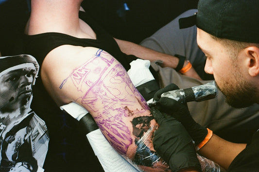 Tattoo artist working on a client's arm